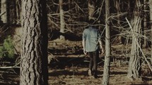 teen boy walking through a forest 