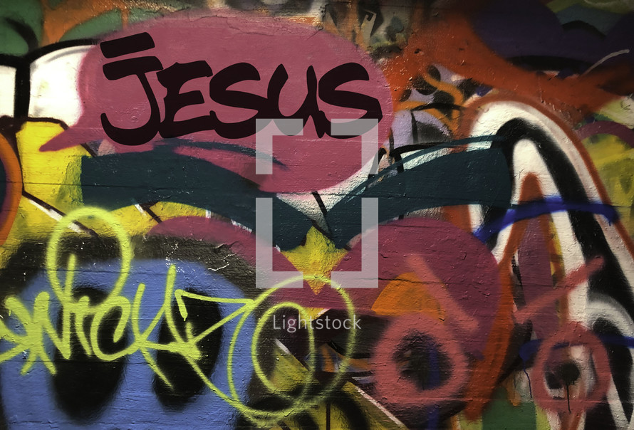 graffiti covered wall with word Jesus 