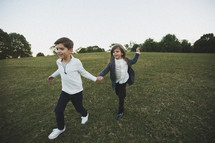 siblings running holding hands 