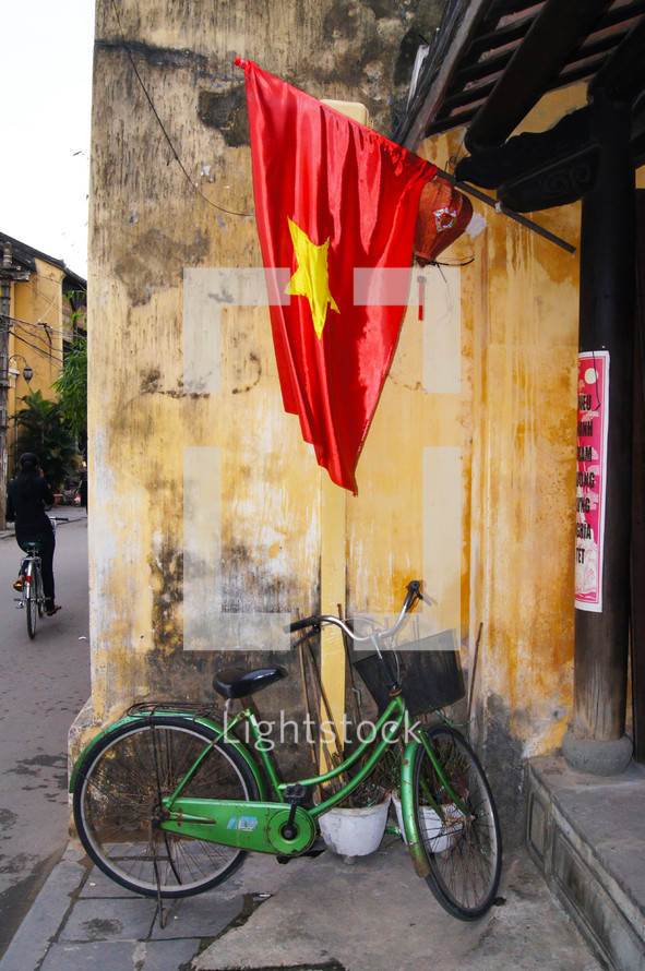 A bike sitting under a Vietnamese flag