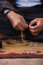 Man praying using prayer beads.