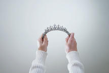 woman holding up tiara 