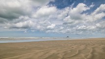 White clouds moving over ninety mile beach in New Zealand wild landscape Time lapse
