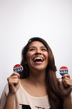 young woman holding vote buttons 