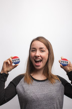 young woman holding vote button 
