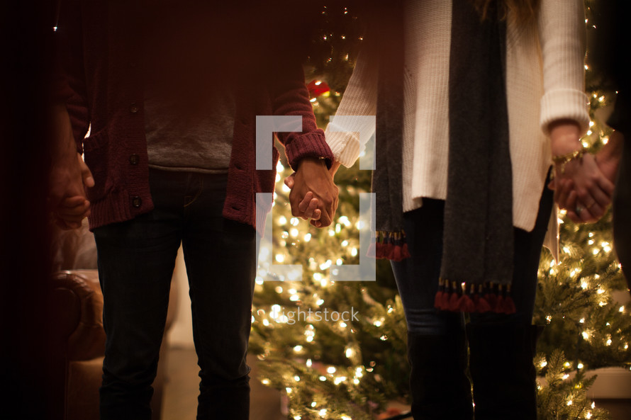 holding hands in prayer at a Christmas party 