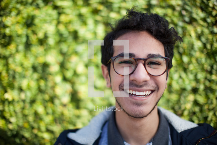 face of a smiling man in glasses 