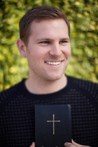 smiling man holding a Bible 