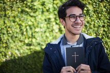 a smiling man holding a Bible 