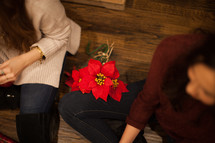 women sitting on the floor at a Christmas party and poinsettias 