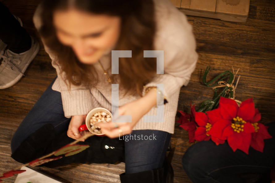 women sitting on the floor at a Christmas party and poinsettias 