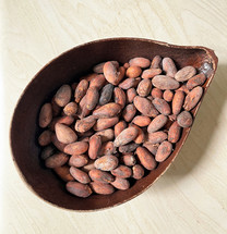 Wooden bowl of roasted cocoa beans
