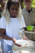 serving soup at a soup kitchen outdoors 