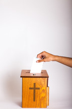 placing an envelope in the offering box 
