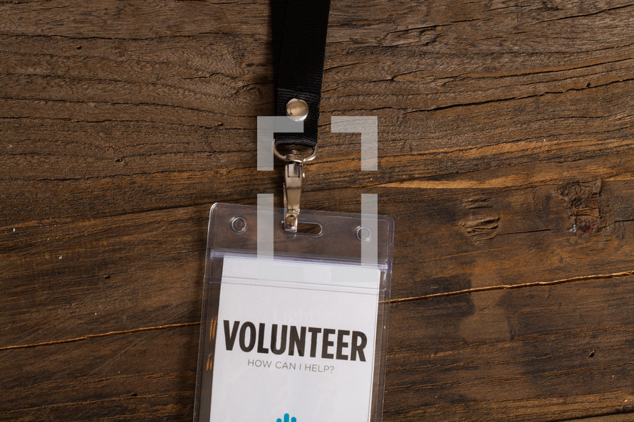 A volunteer badge clipped to a lanyard.