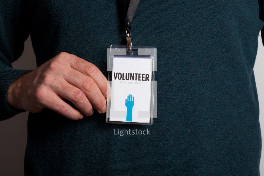 A man wearing a volunteer badge.