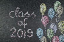 chalk on slate with balloons and the words: class of 2019