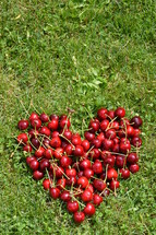 My sweetheart - Fresh cherries in a heart shape in the grass.