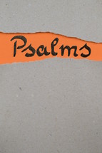 torn open kraft paper over orange paper with the name of the book of Psalms