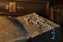 rosary with very old ancient books and bibles in old German lettering