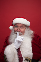Santa with his finger to his mouth 