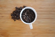 overhead coffee mug filled with coffee beans 