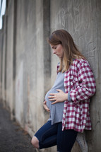 teen girl holding her pregnant belly 