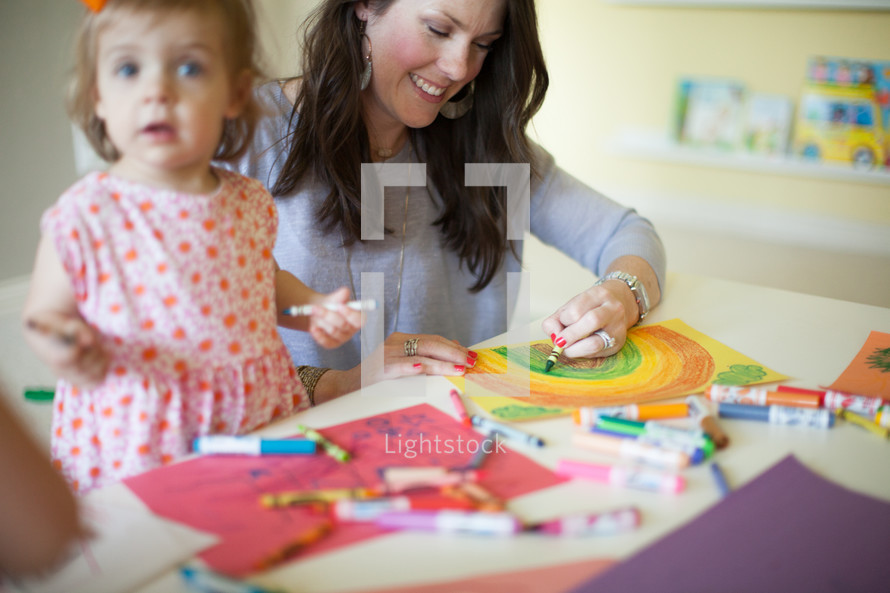 a toddler coloring with mom