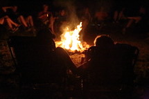 people sitting around a campfire 