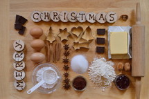 Baking ingredients with wooden pieces and the words MERRY CHRISTMAS burned into them