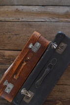 two old weathered suitcases on a rustic wooden floor