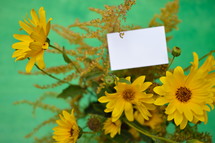 yellow flowers and a blank piece of white paper 