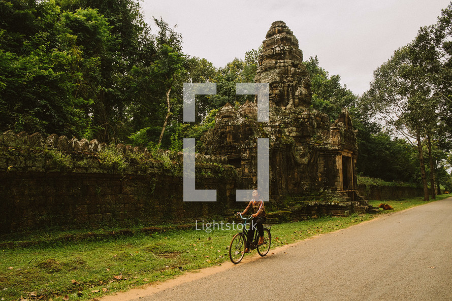 temple ruins and a man on a bicycle 
