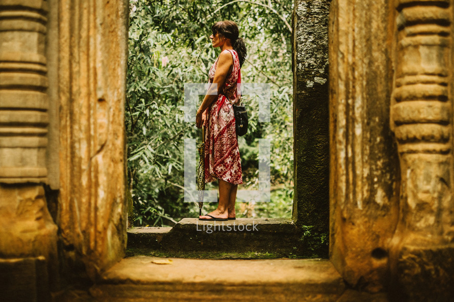 A woman standing in the entrance of temple ruins