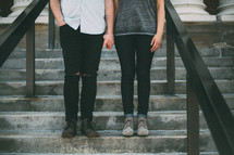 couple holding hands standing on steps 
