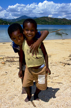 little boys hugging on a beach 
