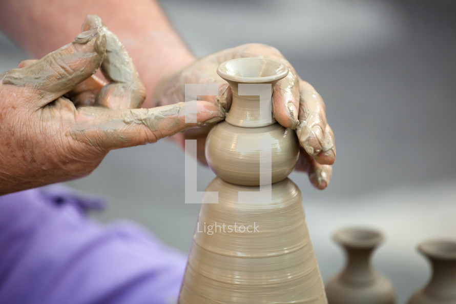 Close up of hands making pottery on a wheel