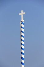 Cross on a striped pole.