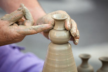 Close up of hands making pottery on a wheel