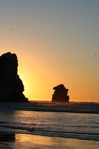 rock formations in the ocean at sunset