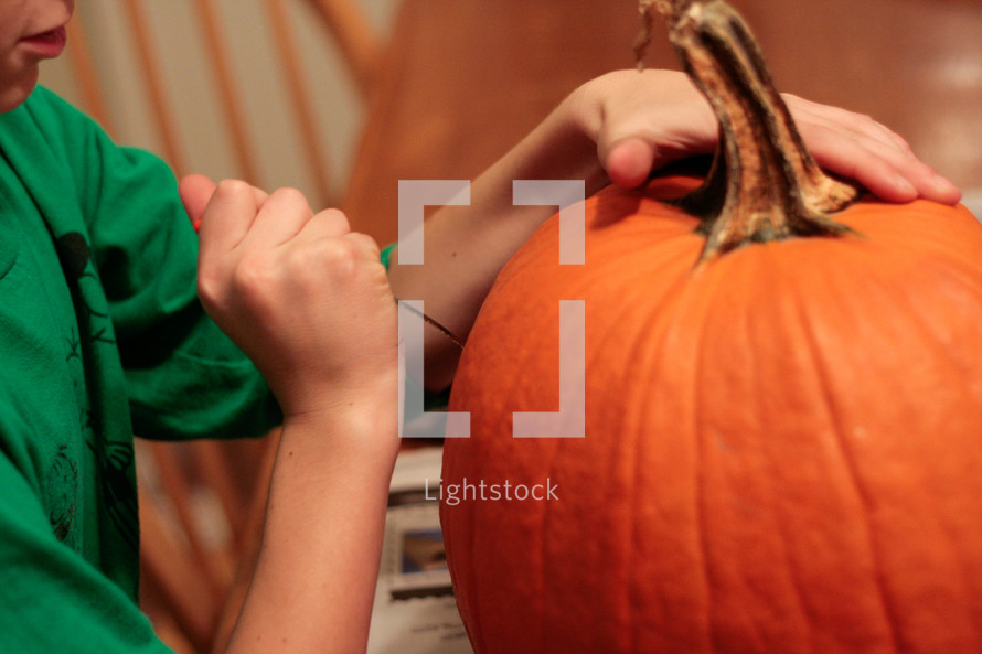 boy carving a pumpkin 