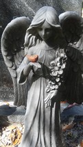 angel statue in a cemetery with bird 
