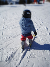 little 3 years old child skiing,
