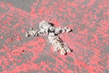Ashes in the shape of a cross in a pink chalk drawn heart  - Ash Wednesday and Valentine's Day February 14, 2018