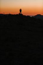 silhouette of a couple against an orange sky 