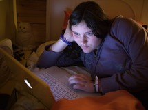 teen girl using a laptop at night 