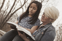 a woman and a child reading a Bible together 
