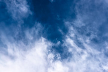 wispy, puffy clouds in a blue sky 