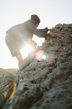 a man climbing up rocks 