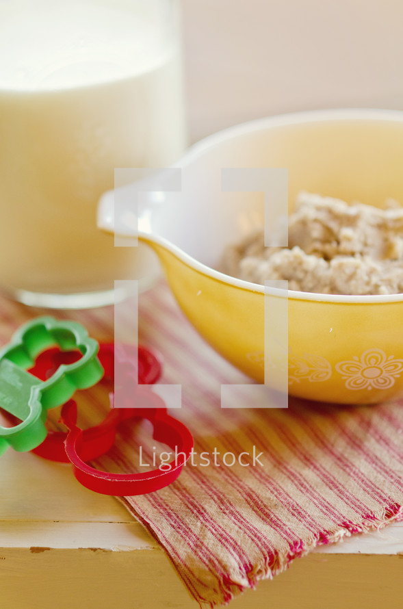 bowl of cookie dough and Christmas cookie cutters and milk